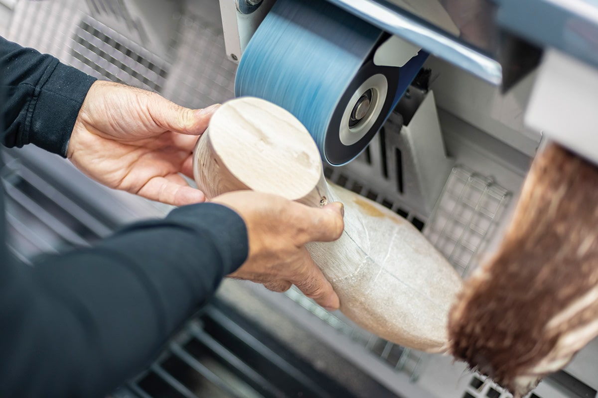 Schleifarbeiten an einem Holzleisten in der Werkstatt